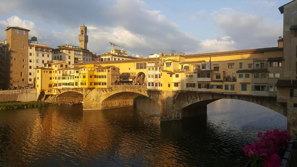 a bridge over a river in a city with buildings at Specchi Su Pontevecchio in Florence