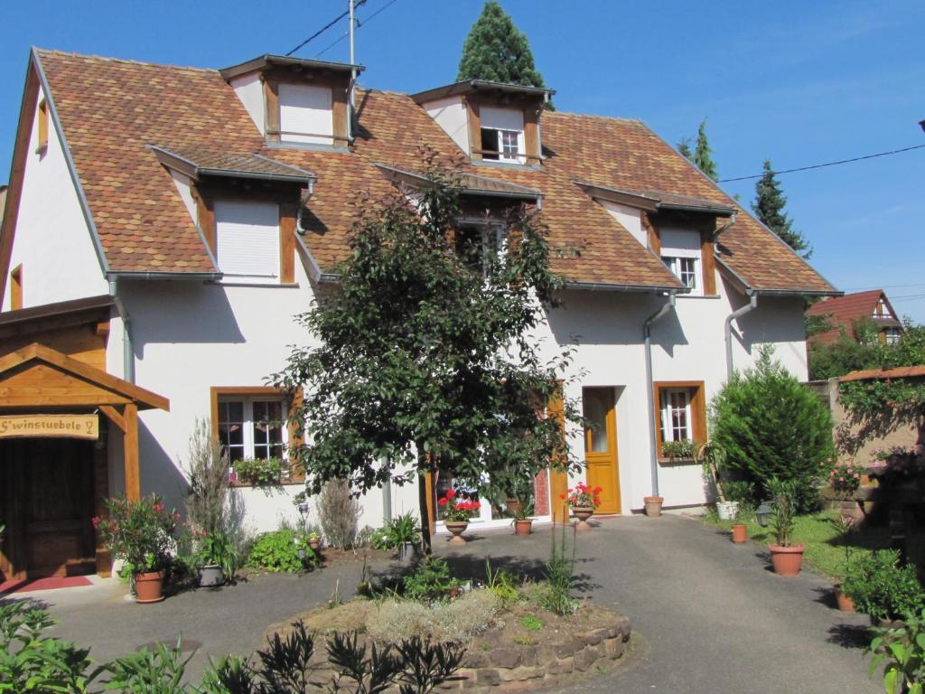 une grande maison blanche avec un toit dans l'établissement Maison d'Hôtes Douce Nuit, à Obermodern