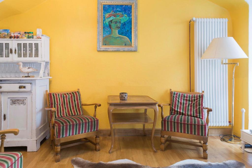 sala de estar con 2 sillas, mesa y una pintura en Haus zum Einhörnle, en Constanza