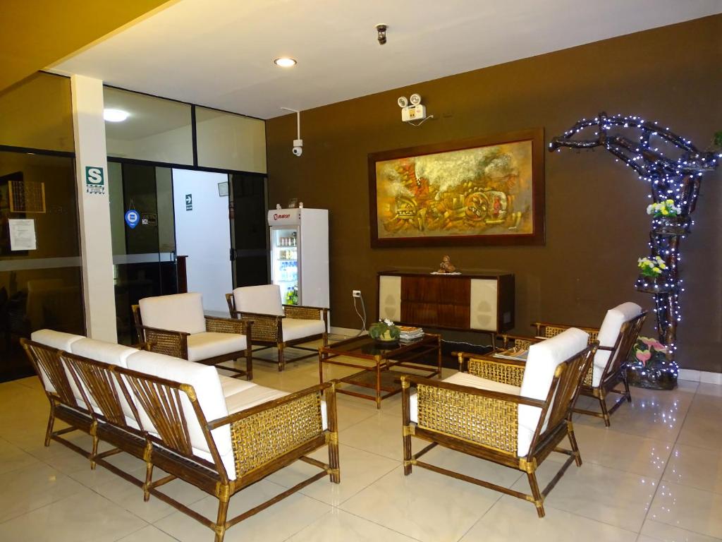 Hospedaje Dimar Inn في ليما: غرفة معيشة فيها كراسي وطاولة وتلفزيون