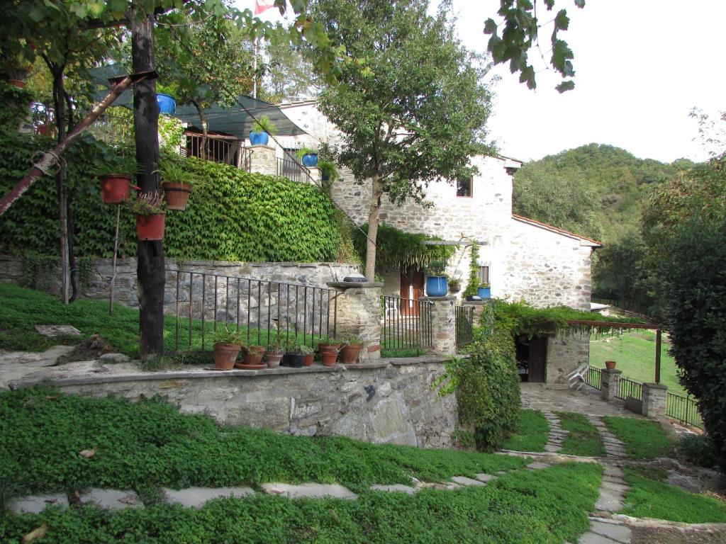 a stone house with a fence and a garden at B&B Dagnano Basso in Pieve Santo Stefano