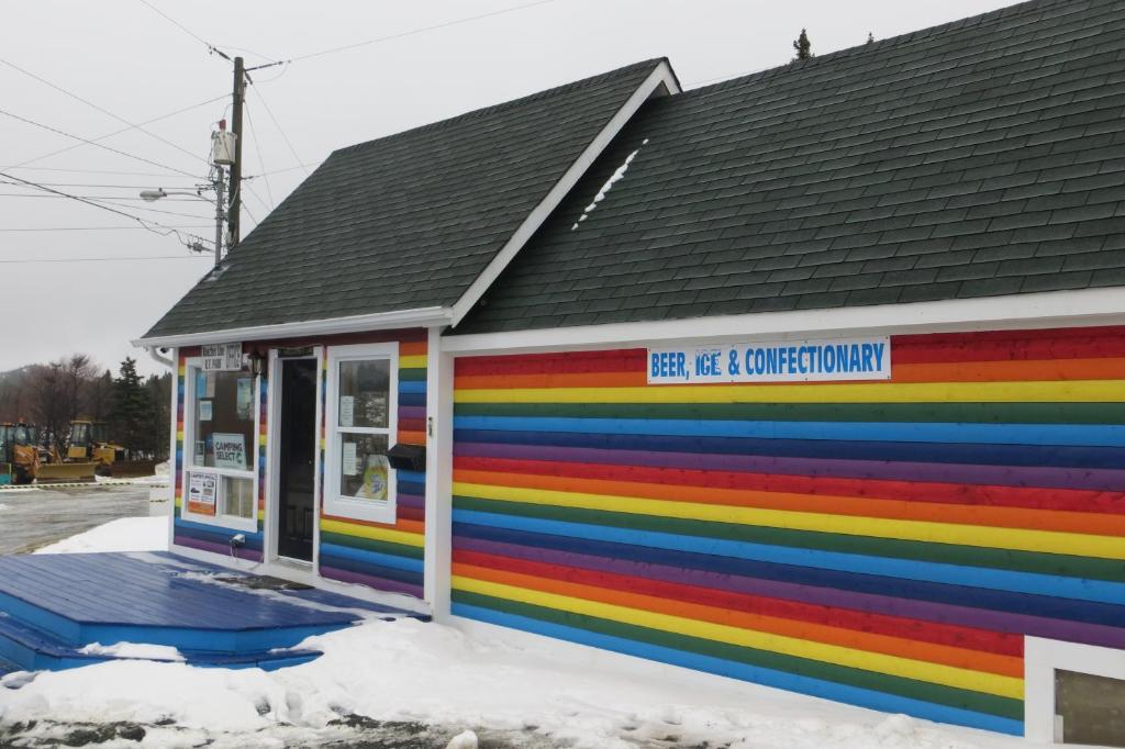 a rainbow colored building with a sign on it at Hillside Cottages in Bay Roberts