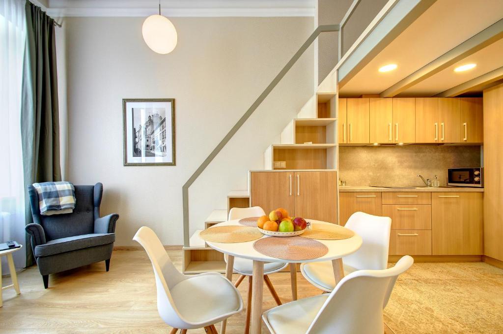 uma sala de estar e cozinha com mesa e cadeiras em Sodu15 Apartments em Vilnius