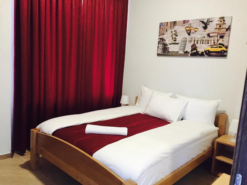 Becar Pyramid Rooms في فيسوكو: غرفة نوم بسرير وستارة حمراء