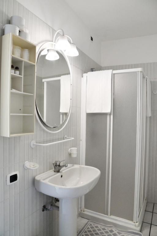 een witte badkamer met een wastafel en een douche bij Briisa De Ness in Nesso