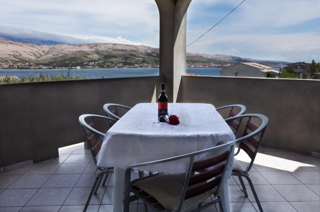 una mesa con una botella de vino en el balcón en Apartment Anamaria, en Pag