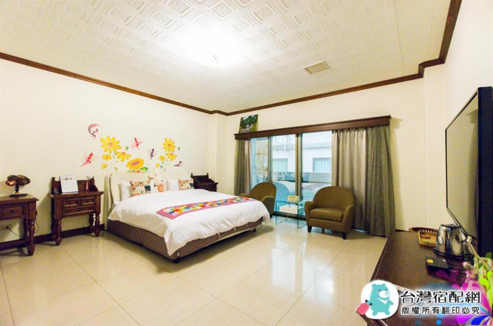 una camera da letto con un letto, una scrivania e una sedia di Tainan Yi Home a Tainan