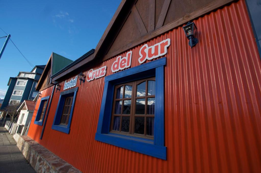 um edifício laranja com um sinal na lateral em Hostel Cruz del Sur em Ushuaia