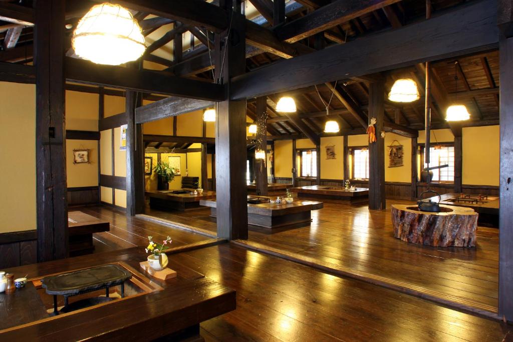 a large room with a wooden floor and wooden floors at Syukubo Aso in Aso