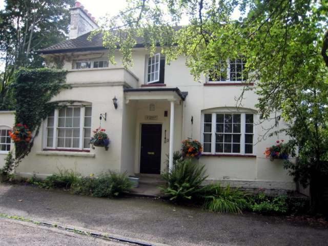 Una casa blanca con una puerta y flores. en Bluebell House, en Windsor