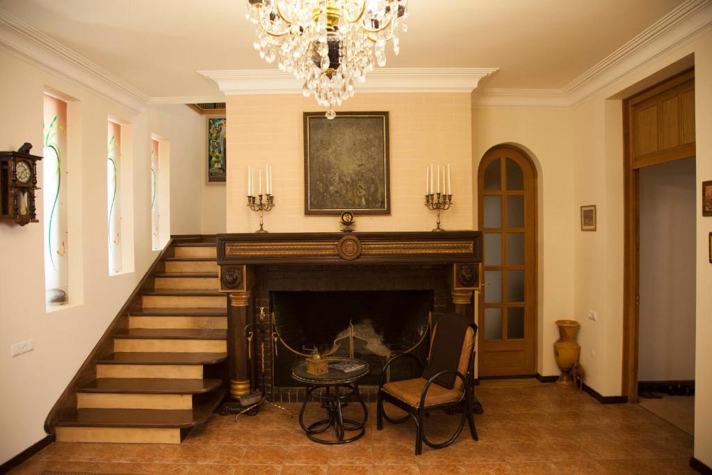 a living room with a fireplace and a chandelier at Hin Yerevantsi Hotel in Yerevan