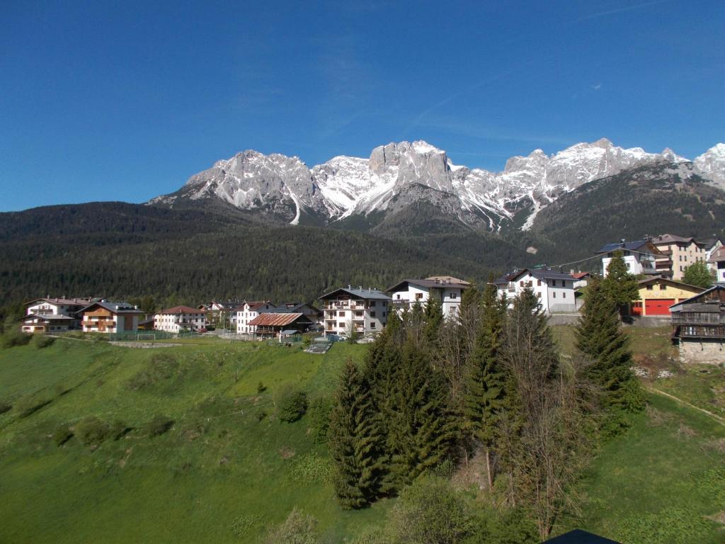 un village avec des montagnes enneigées en arrière-plan dans l'établissement Balcone sulle Dolomiti, à Comelico Superiore