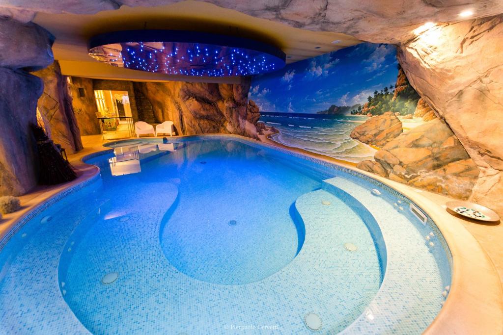 una piscina coperta in una grotta con parete di roccia di Paradise Hotel & Wellness a Saint Vincent