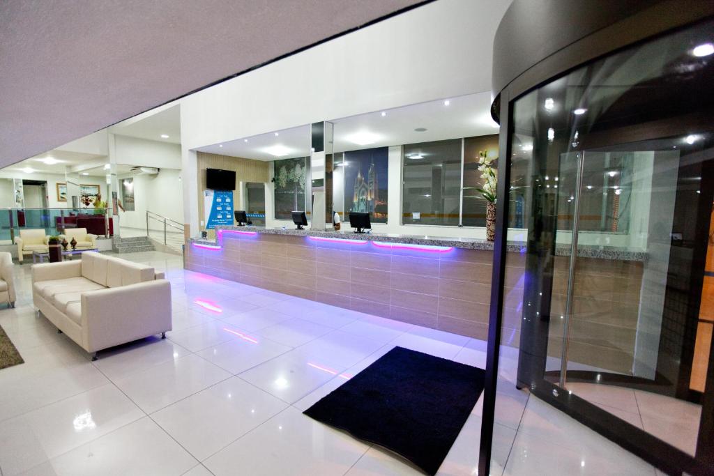 a lobby with a waiting area with purple lights at JB Hotel in Petrolina