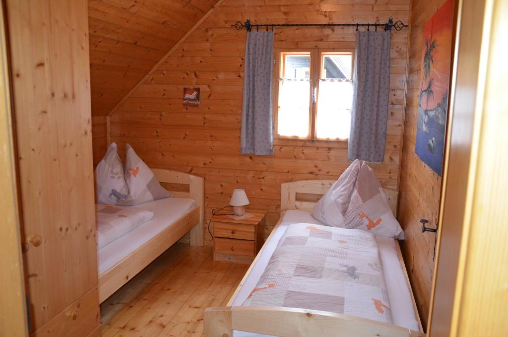 - une chambre avec 2 lits dans une cabane en rondins dans l'établissement Ferienhaus Anna, à Donnersbachwald