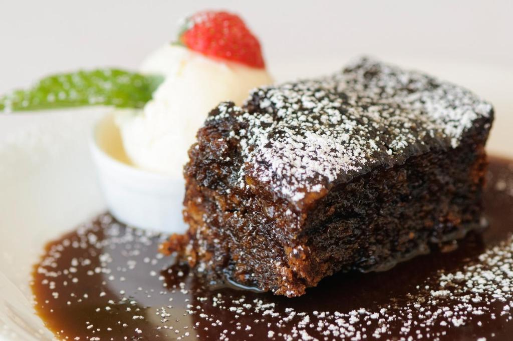 un trozo de pastel de chocolate con una fresa en un plato en Doonmore Hotel, Bar & Restaurant en Inishbofin