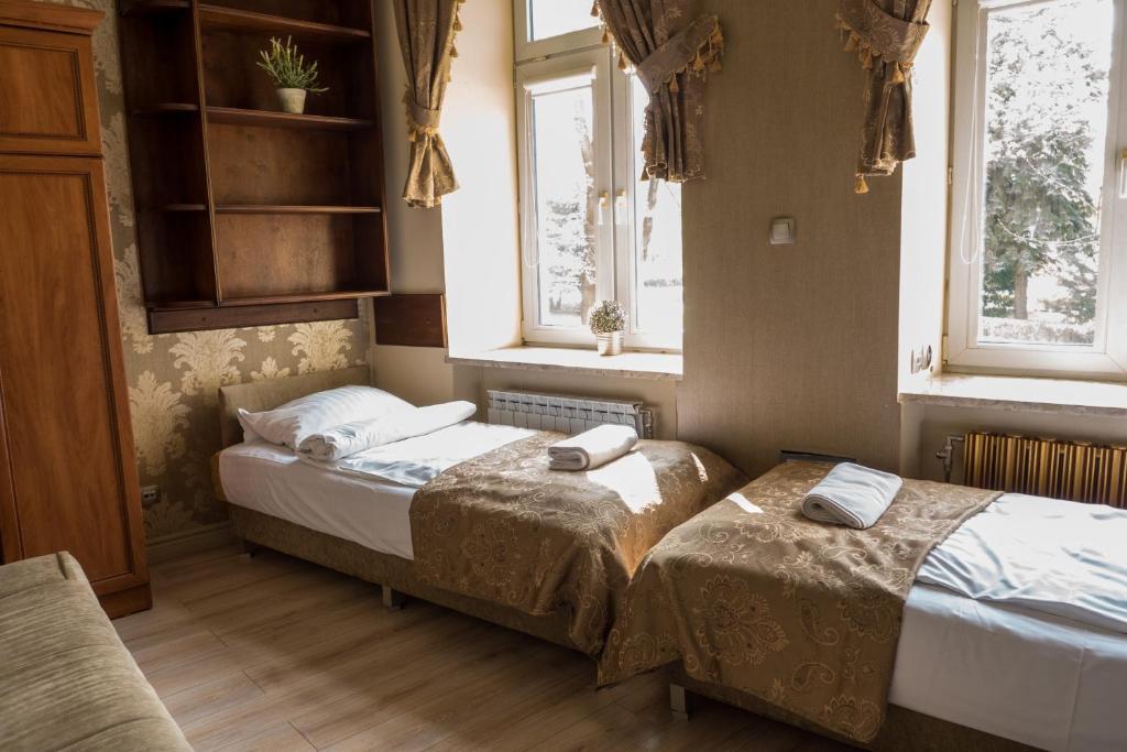 2 camas en una habitación con 2 ventanas en The Center Apartments, en Rzeszów