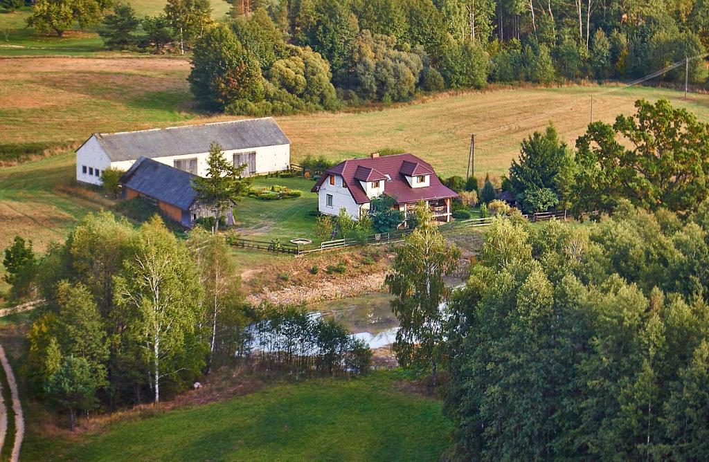 eine Luftansicht eines Hauses und einer Scheune auf einem Feld in der Unterkunft Gospodarstwo agroturystyczne Biebrzanska Goscina in Karcewo