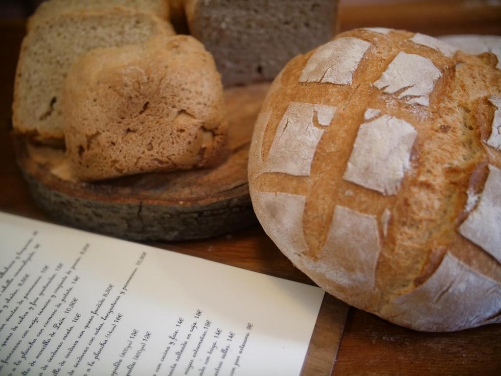 two loaves of bread sitting on a table with a paper at Albergue de Portilla in Portilla de la Reina