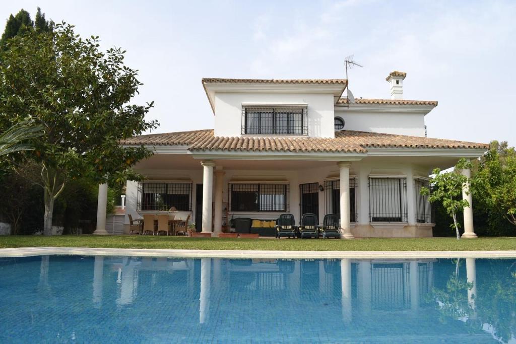 una casa con piscina frente a ella en Villa las Redes, en El Puerto de Santa María