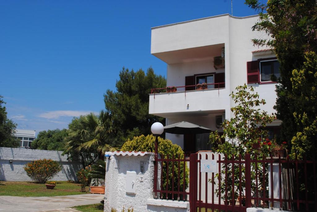 una casa blanca con una valla roja en Annavi, en Bari