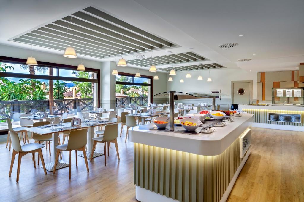 una sala da pranzo con tavoli e sedie in un ristorante di Barceló Marbella a Marbella