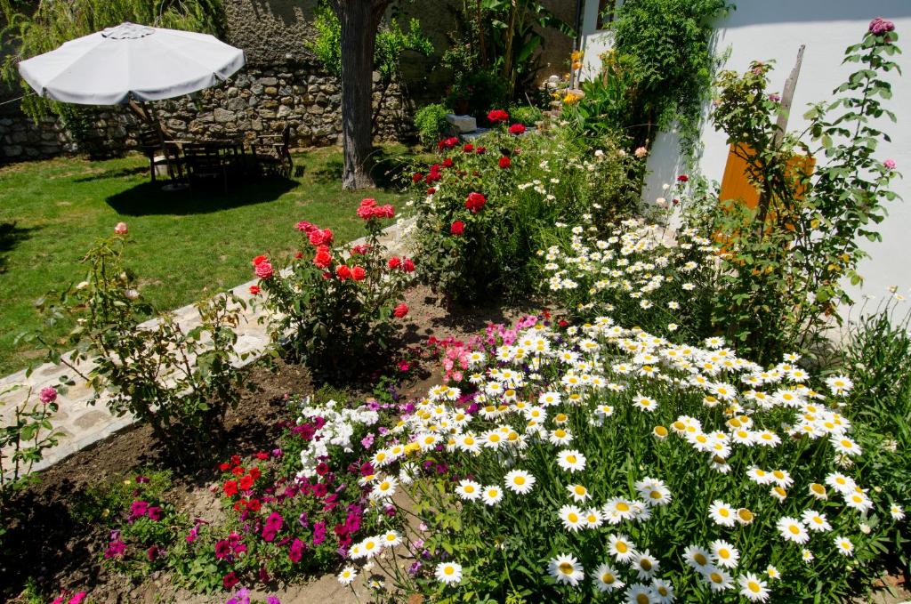 a garden with colorful flowers and an umbrella at Garden House in Selçuk