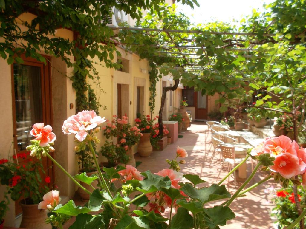 een tuin met bloemen, tafels en stoelen bij Villa Orestis in Archanes