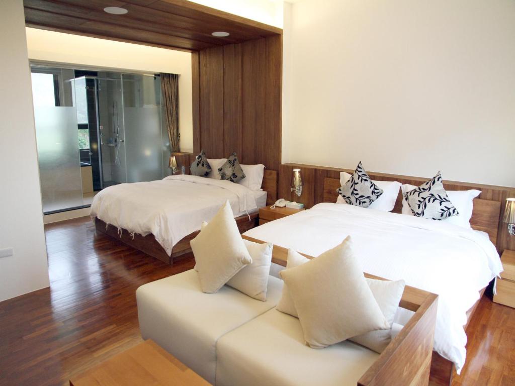 Habitación de hotel con 2 camas y sofá en Peace Area Hot Spring Hotel en Jiaoxi