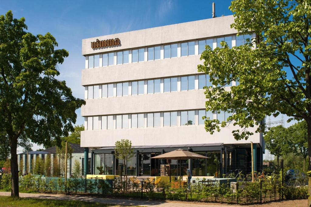 een gebouw met een café ervoor bij Hotel Nimma in Nijmegen