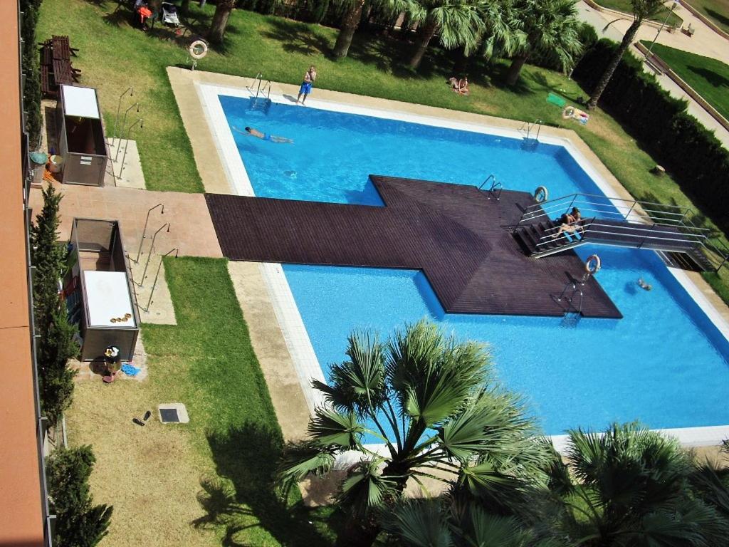 an overhead view of a large swimming pool with palm trees at Goleta Almeria in Almería