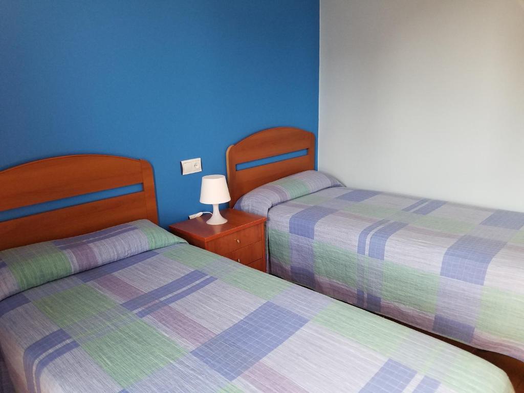 two beds in a room with blue walls at Hotel Condes de Buñol in Buñol