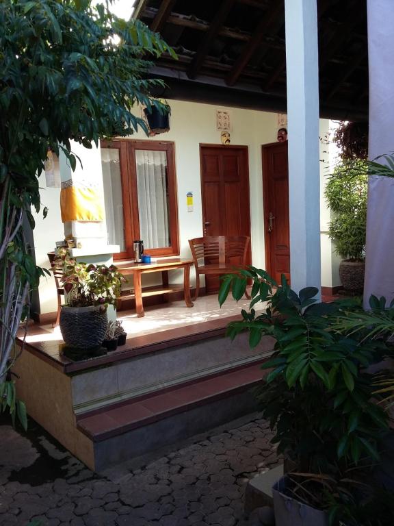 un porche de una casa con un banco y plantas en Wahwik&#39;s House, en Ubud