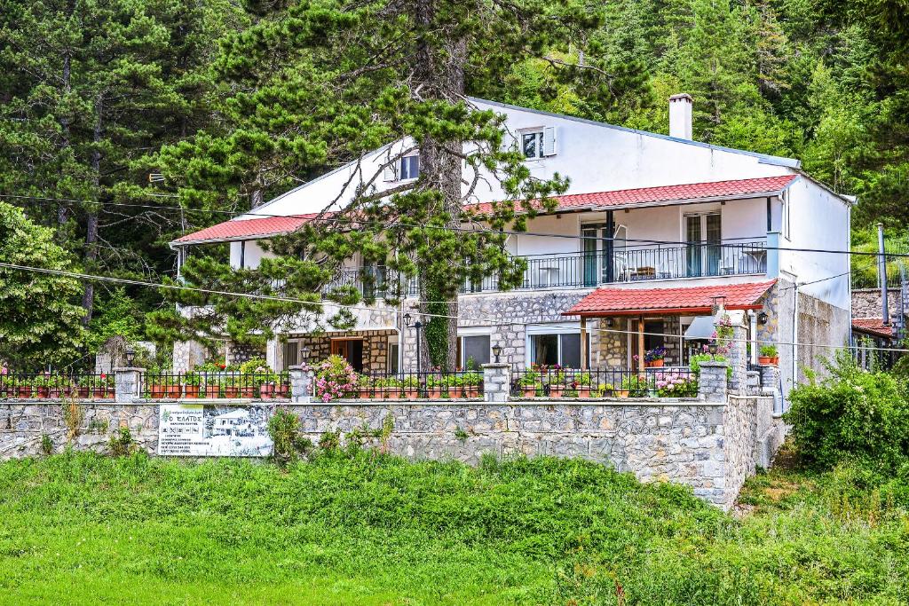 a house on a hill with a stone wall at O Elatos in Loutra Amarantou