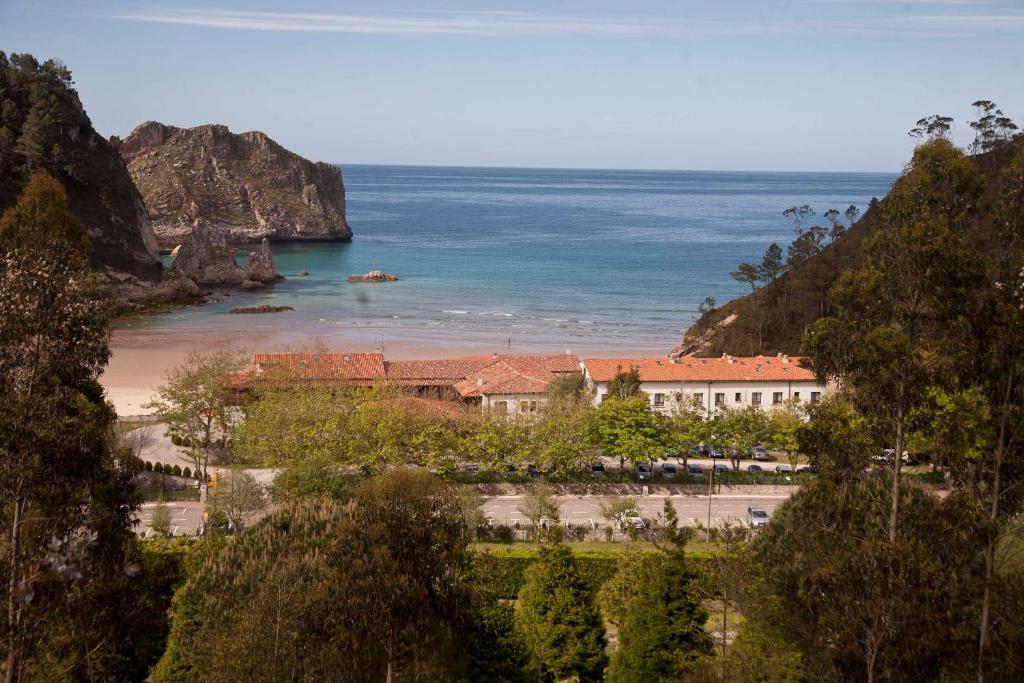 a building on a beach next to the ocean at Hotel Mirador de La Franca in La Franca