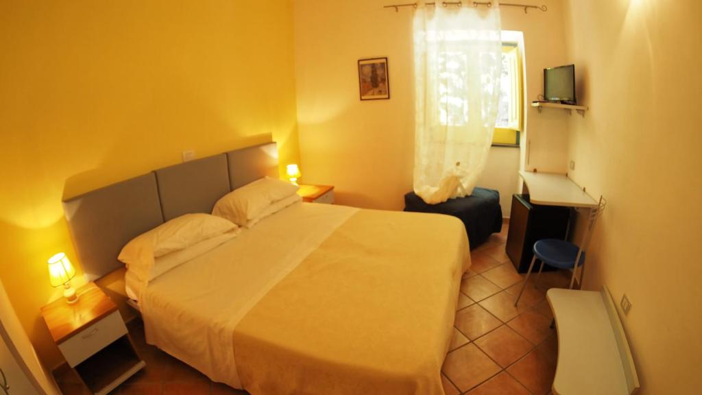 a bedroom with a large white bed and a window at Solcalante in Procida