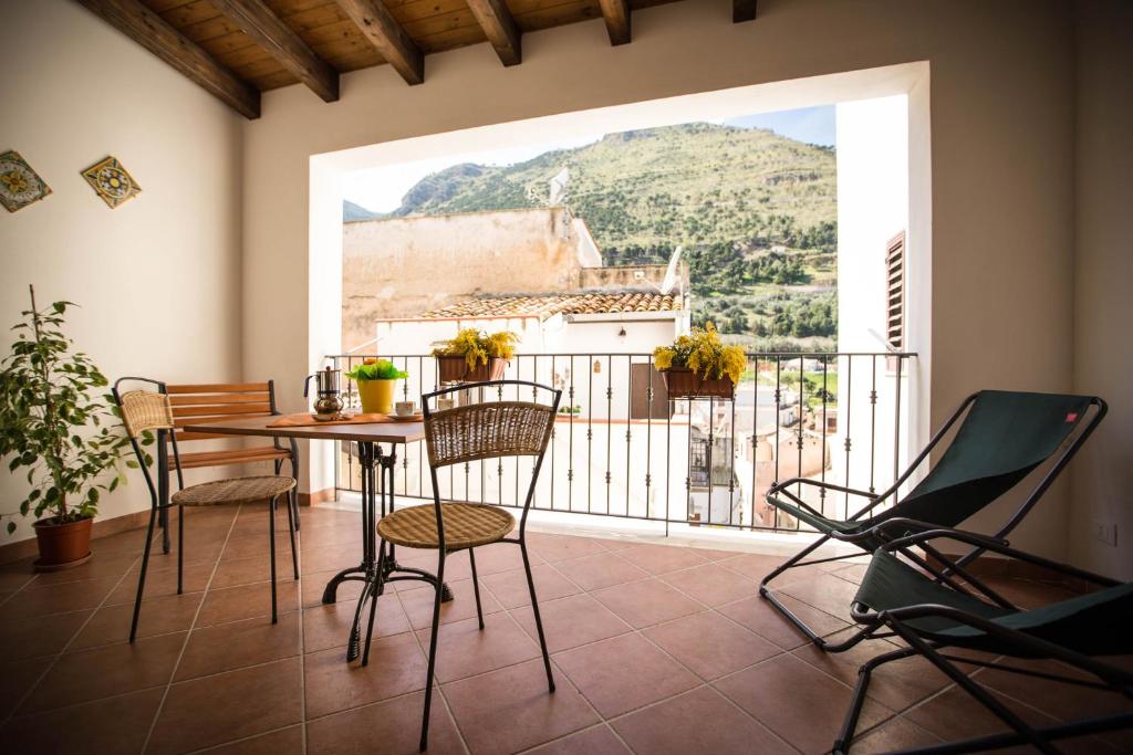 a room with a table and chairs and a large window at Appartamento gli archi a 100 metri dalla spiaggia in Castellammare del Golfo
