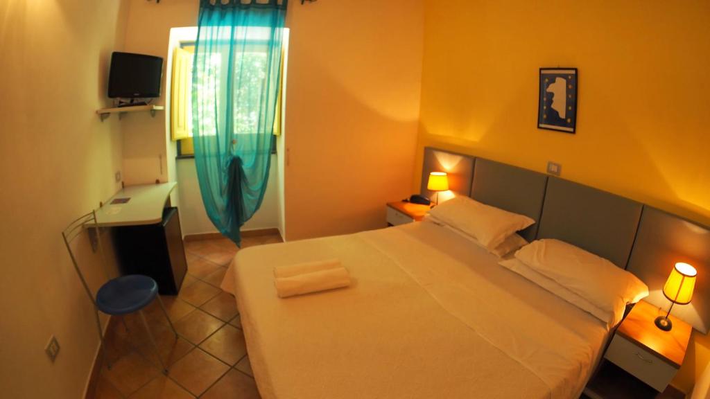 a bedroom with a large bed and a television at Solcalante in Procida