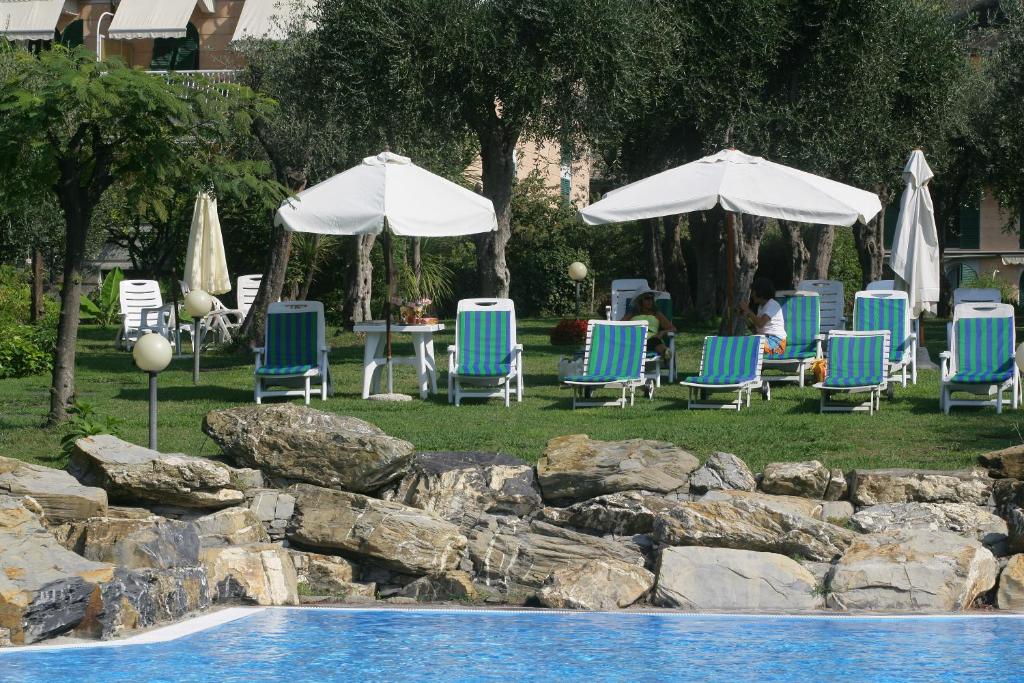 grupa leżaków i parasoli przy basenie w obiekcie Il parco sul golfo w Genui