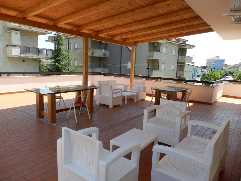 a patio with tables and white chairs on a roof at B&B SoleLuna in Torretta