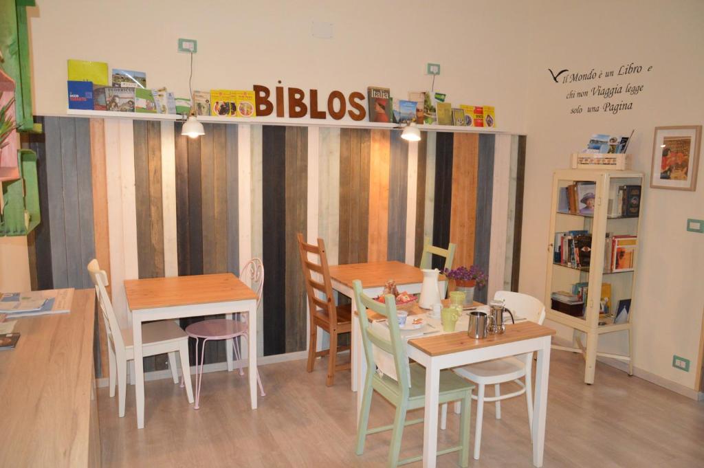 un comedor con dos mesas y un cartel que lee amigos en Biblos e Mare, en Taranto