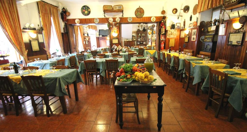 ein Restaurant mit Tischen und Stühlen sowie Obst auf einem Tisch in der Unterkunft Albergo Santo Spirito in Molini di Triora