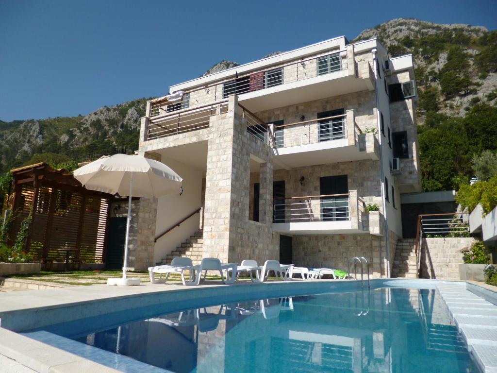 a house with a swimming pool in front of a building at Villa "M Family" in Kotor