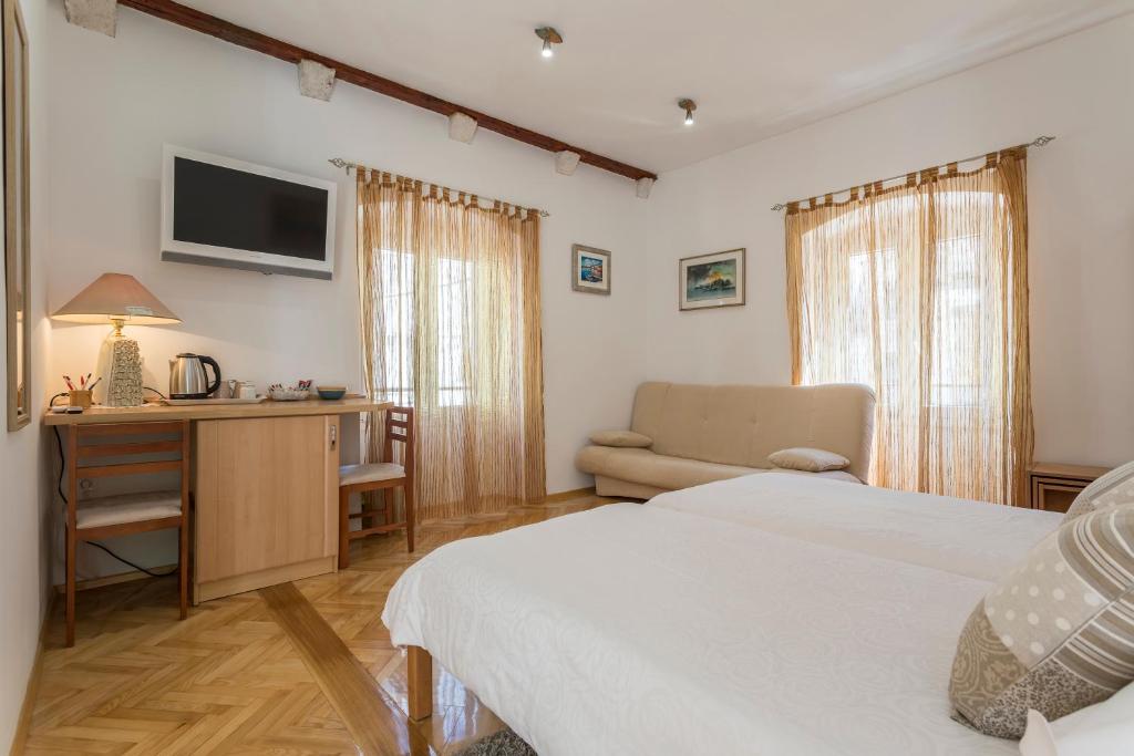 um quarto com uma cama, uma secretária e uma televisão em Carrara Accommodation em Split