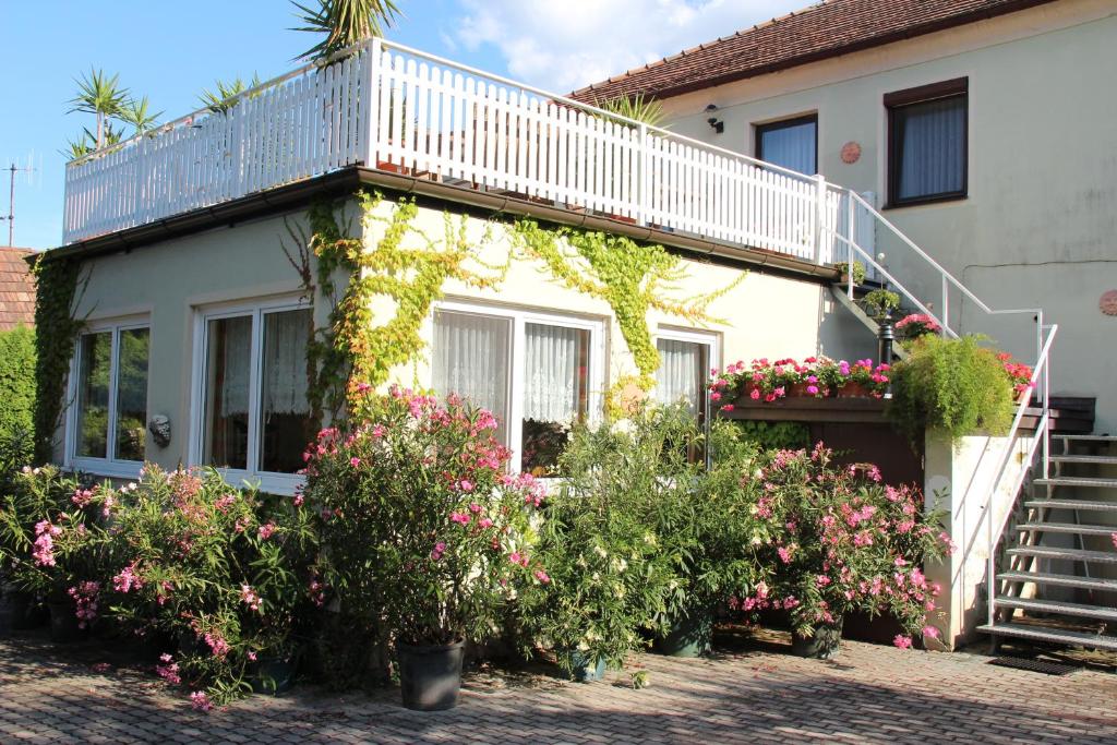 een huis met een balkon en een aantal bloemen bij Weingut Pension Sommerhof in Mörbisch am See