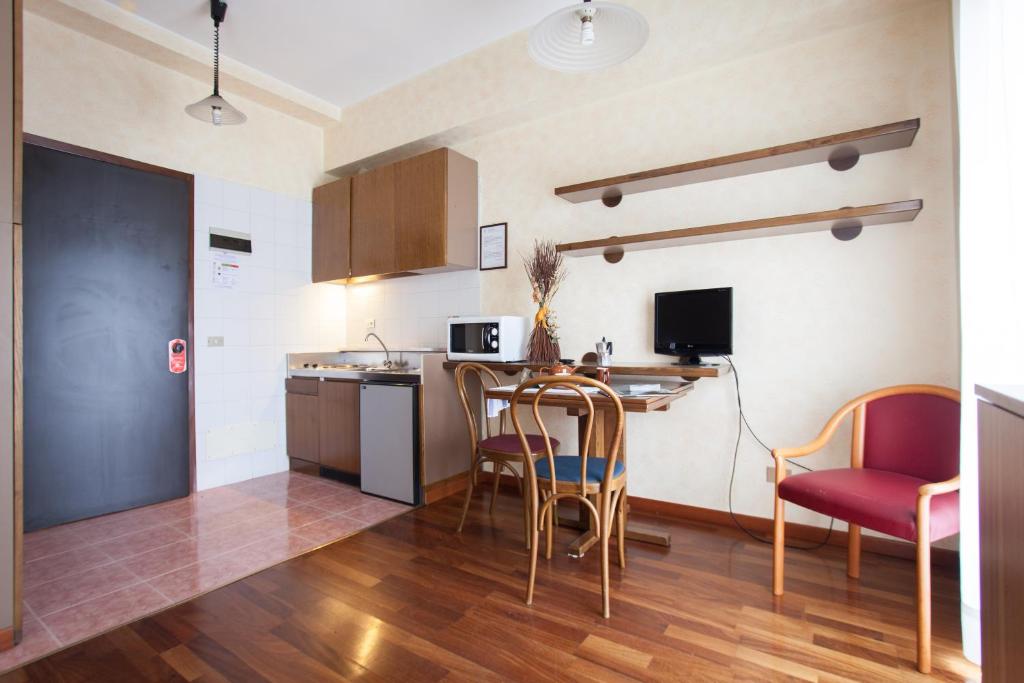 una cucina con tavolo e sedie in una stanza di Residence Desenzano a Milano