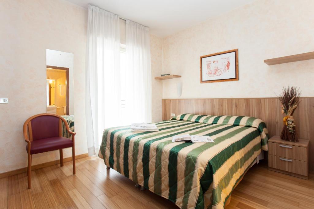 een hotelkamer met een bed en een stoel bij Residence Desenzano in Milaan