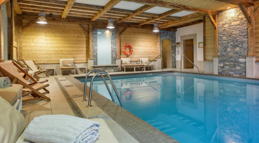 una piscina en una habitación con paredes de madera en CGH Résidences & Spas Le Ruitor, en Sainte-Foy-Tarentaise