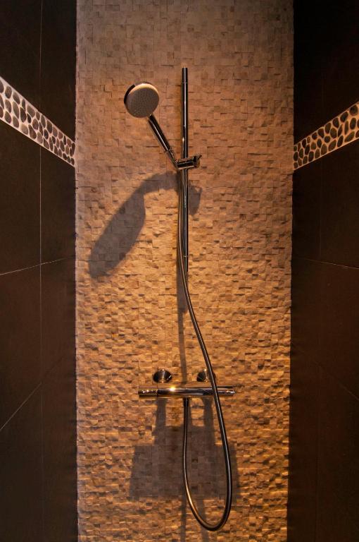 bagno con doccia e parete in mattoni di Hostel Lybeer Private Rooms just for two! a Bruges