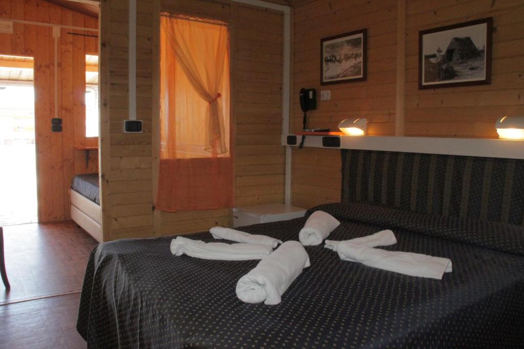 um quarto com toalhas brancas numa cama em Hotel Paradiso Dei Giovani em Margherita di Savoia